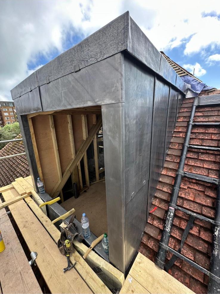 Lead-clad dormer built on a tiled roof
