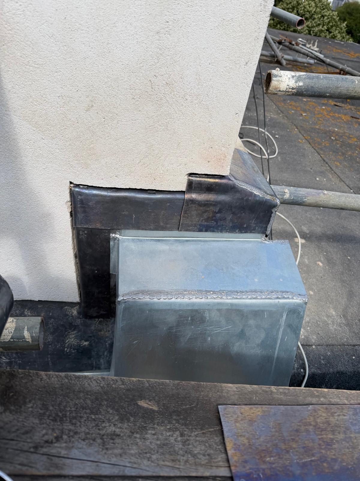 Roof repair around a rendered parapet wall