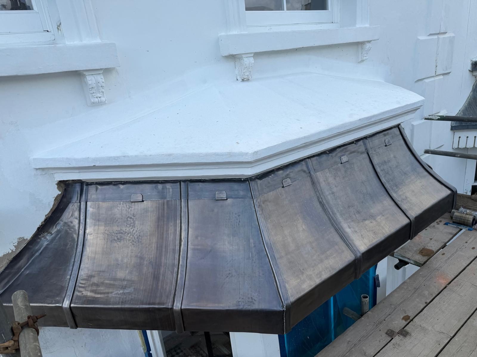 Shaped lead canopy on a white period building